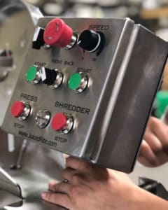 Commercial Juicer Control Panel with knobs for Shredding, Pressing, Speed, Start and Stop. The buttons are red and green on a stainless steel cube.