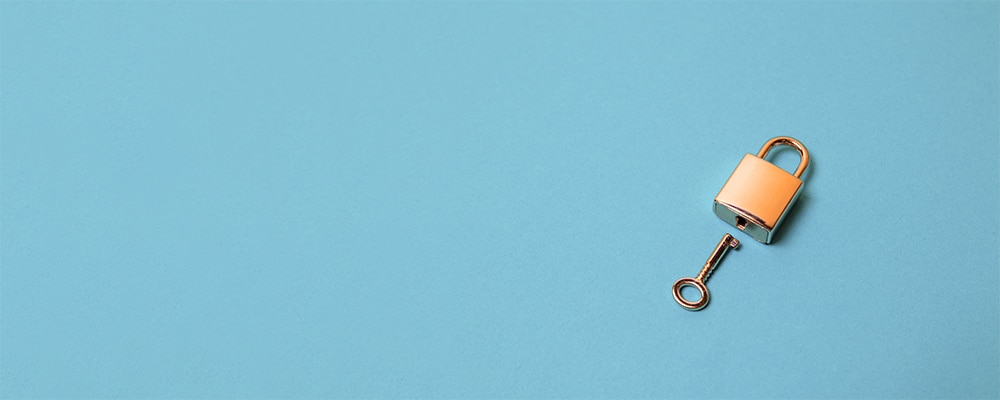 Brass bike lock and key on a blue background