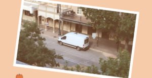 Picture of White Van Across the Street Taken From Atop a Building On an Orange Background With a Logo Apple